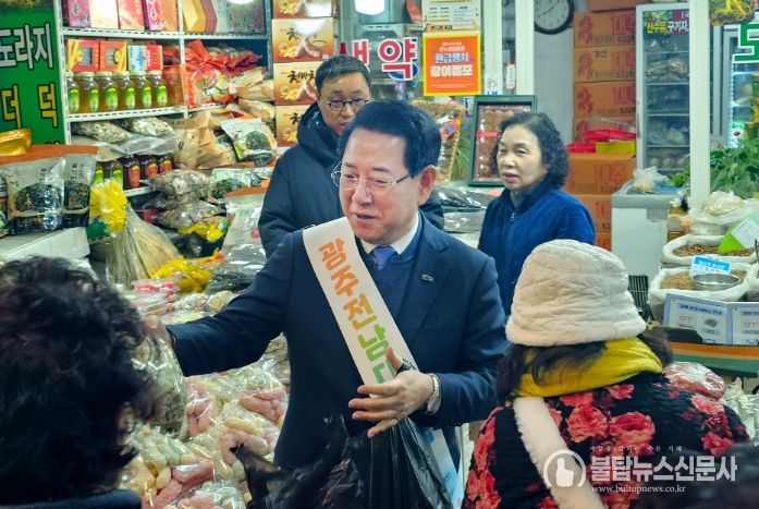 김영록 전남도지사가 설 명절을 앞둔 14일 광주 남광주시장에서 제수용품을 구매하며 상인들을 격려하고 있다.