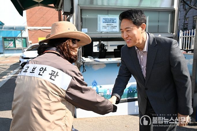 오세훈 서울시장이 13일 서울 소재 초등학교에서 학교보안관과 인사를 나누고 있다.